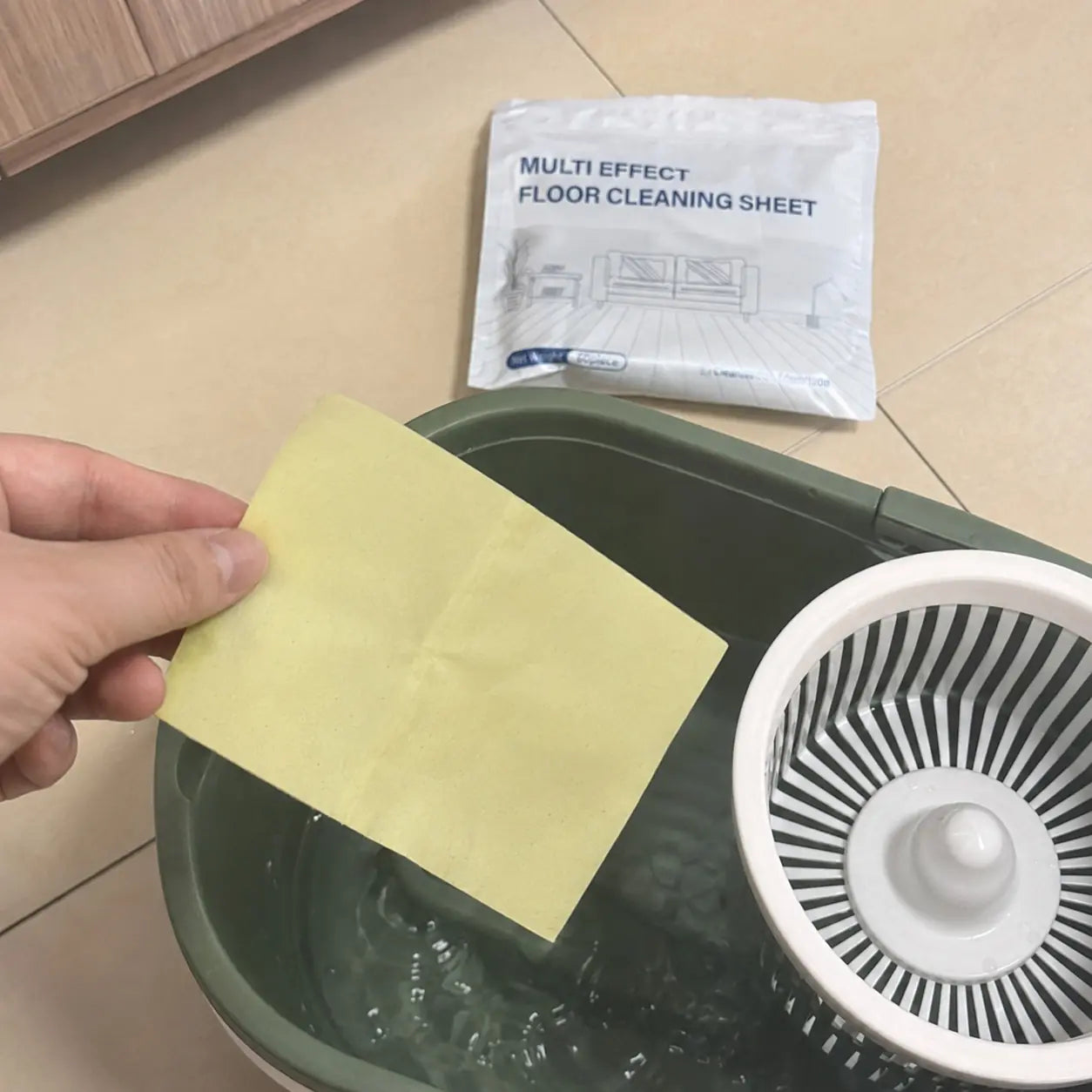 Customer holding a yellow cleaning sheet over a mop bucket